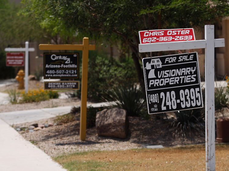 Wie kleine Galgen hängen die Werbeschilder der Makler in den Vorgärten schwer verkäuflicher Häuser in Maricopa, Arizona.