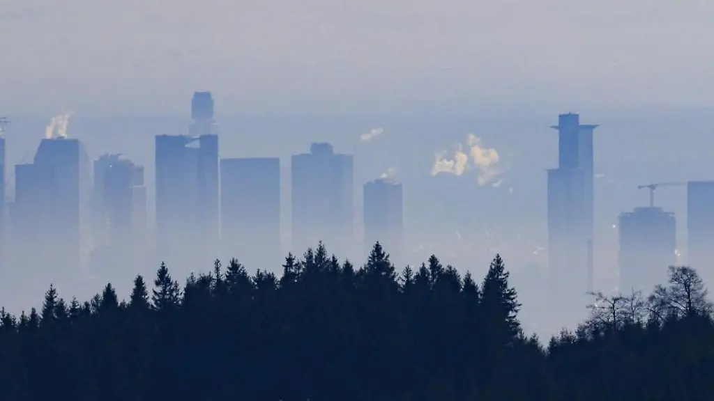 Blick-von-einem-Wanderweg-am-Feldberg-auf-die-Bankenskyline-von-Frankfurt-am-Main-im-Morgendunst