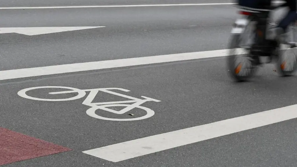 Ein-Radfahrer-faehrt-auf-der-Fahrradspur-einer-Strasse