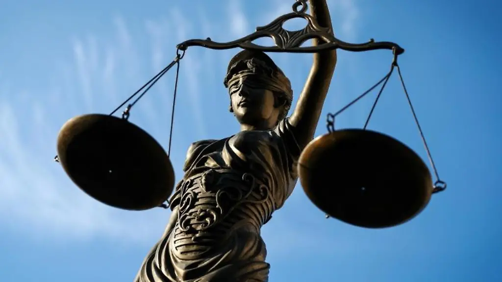 Eine-Statue-der-Justitia-haelt-eine-Waage-in-ihrer-Hand