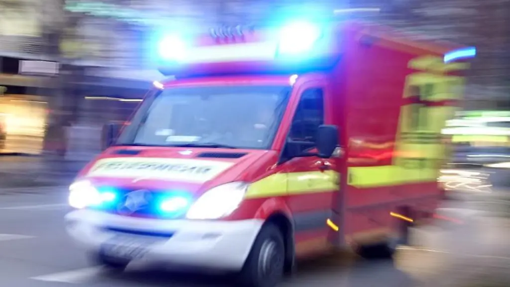 Ein-Krankenwagen-faehrt-mit-Blaulicht-bei-einem-Einsatz-durch-die-Innenstadt