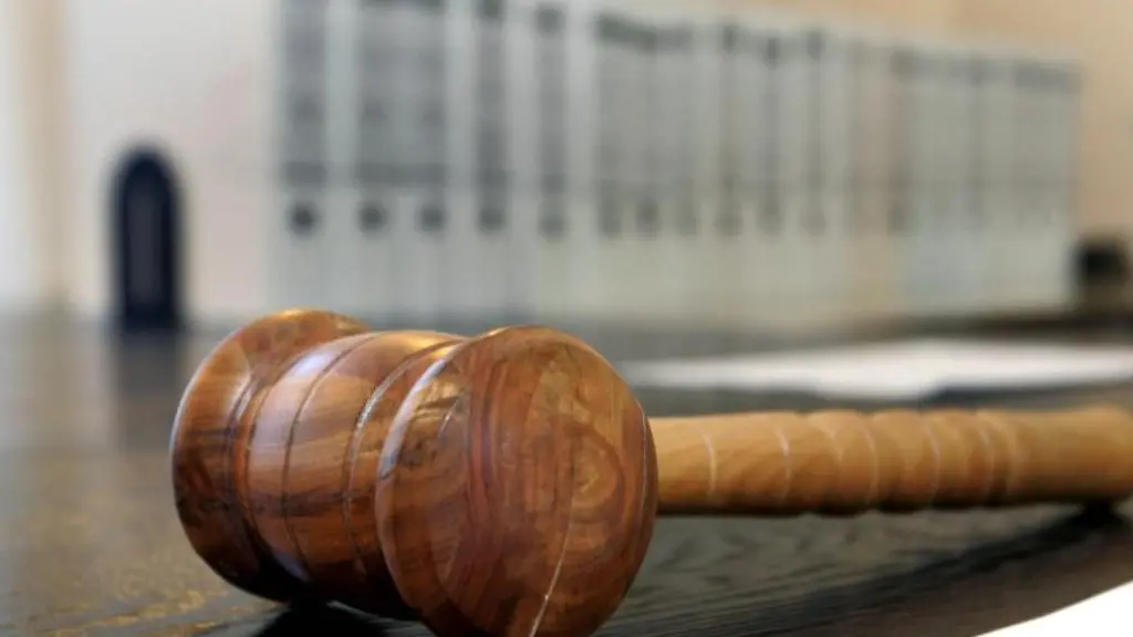 Ein-hoelzerner-Hammer-liegt-auf-der-Richterbank-in-einem-Verhandlungssaal-des-Landgerichts