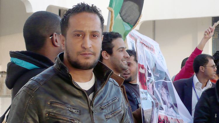 Der Libyer Muftah al-Teira steht beglückt im libyschen Bengasi neben einer Gruppe Männer, die öffentlich ihre Meinung sagen.