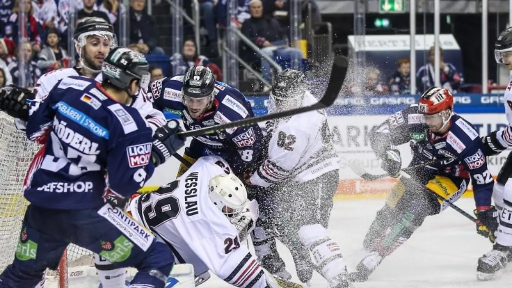 Vor-dem-Tor-von-Gustaf-Wesslau-3-v-l-von-Koelner-Haie-kaempfen-Berlins-James-Sheppard-4-v-l-und-Kevin-Gagne-5-v-l-von-Koelner-Haie-um-den-Puck