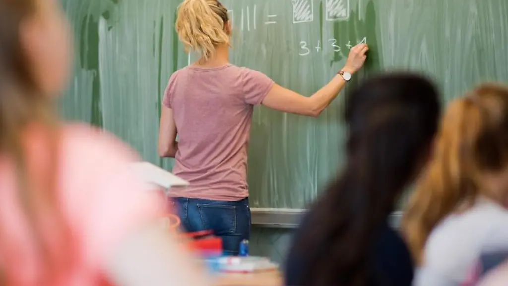 Eine-junge-Lehrerin-schreibt-an-einer-Schultafel