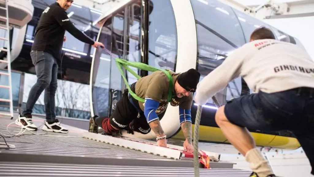 Franz-Muellner-Kraftsportler-befindet-sich-in-Aktion-Er-wird-von-zwei-Helfern-unterstuetzt