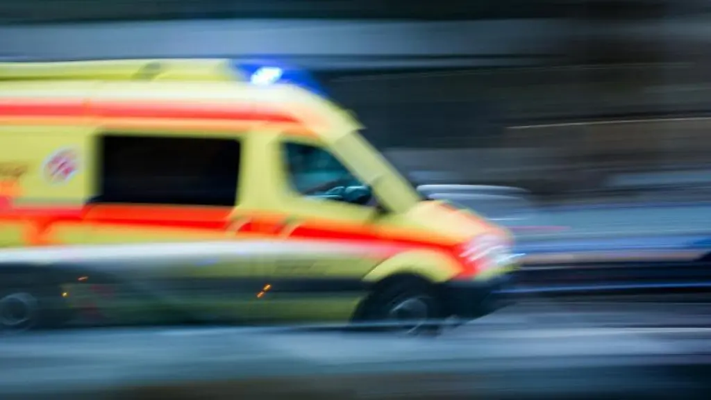 Ein-Krankenwagen-faehrt-mit-Blaulicht-bei-einem-Einsatz-ueber-die-Strasse