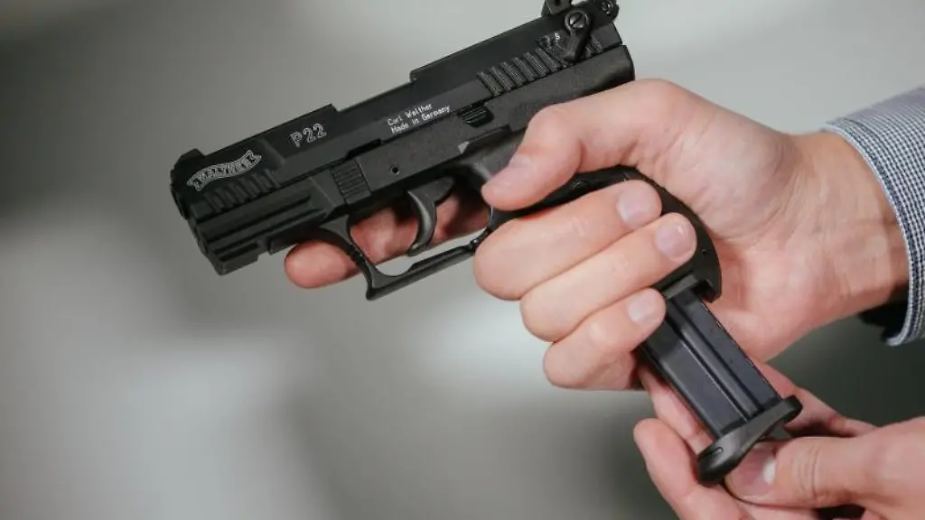 Haende-laden-eine-Schreckschuss-Pistole-Walther-P22-mit-einem-Magazin