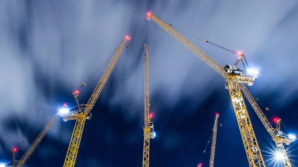 Wolken-ziehen-ueber-Baukraene-auf-einer-Grossbaustelle-hinweg