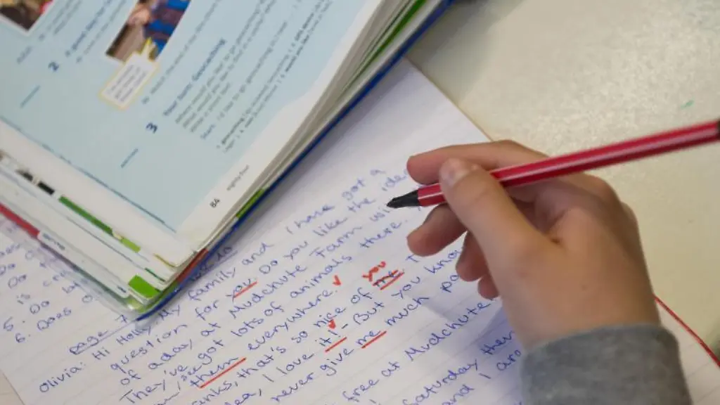 Eine-lernende-Person-haelt-einen-Rotstift-in-der-Hand-Daneben-liegen-ein-Heft-und-ein-Buch