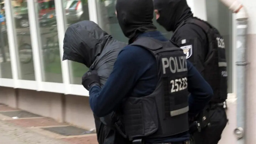 Zwei-Polizeibeamte-fuehren-einen-Mann-ab