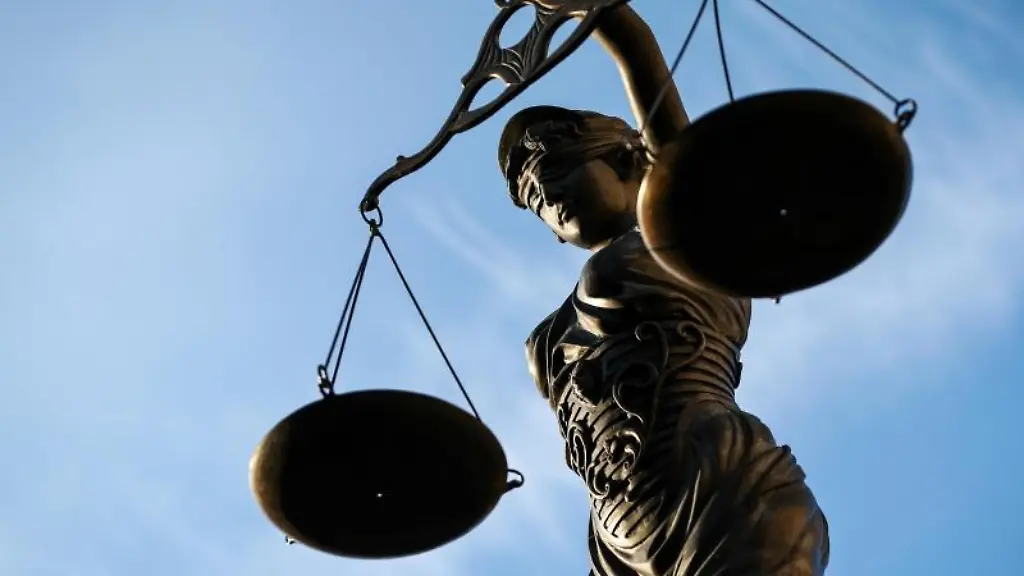 Eine-Statue-der-Justitia-haelt-eine-Waage-in-ihrer-Hand