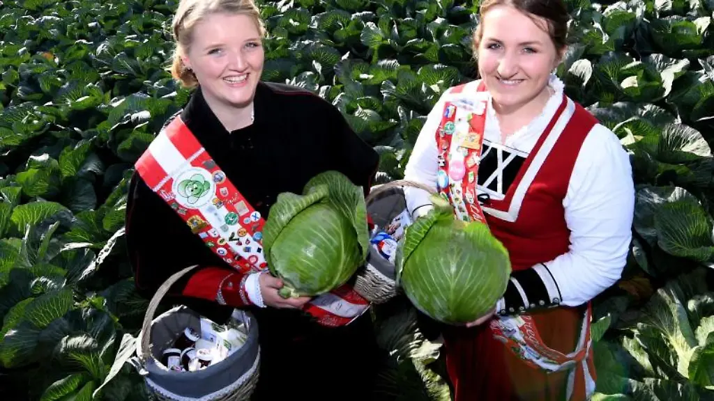Die-Kohl-Regentinnen-Hepke-l-und-Bente-stehen-bei-der-offiziellen-Eroeffnung-der-Dithmarscher-Kohltage-in-einem-Kohl-Feld