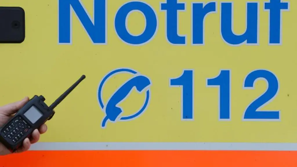 Ein-Sanitaeter-vor-einem-Rettungswagen-mit-der-Nummer-des-Notrufes