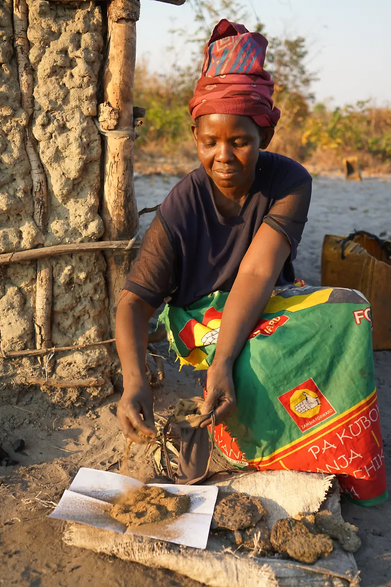 Nowana-45-fills-a-pouch-with-powdered-cow-patties-that-she-uses-during-her-period-Nowana-45-uses-powdered-cow-patties-in-a-pouch-used-during-menstruation-I-would-prefer-pads-to-cow-patties-if-I-had-a-choice-They-are-easy-and-already-made-they-are-disposable-and-don-t-require-a-lengthy-process-like-the-one-I-go-through-when-using-cow-patties-Mongu-District-Zambia-August-2018