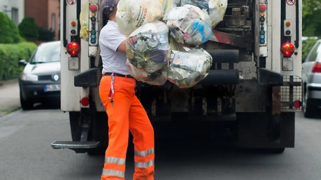 Ein-Mitarbeiter-der-Abfallwirtschaft-Region-Hannover-wirft-gelbe-Saecke-in-einen-Muellwagen
