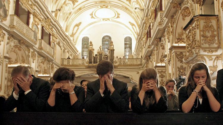 Angehörige trauern in einem katholischen Gottesdienst um die Opfer der Katastrophe. Anwälte versuchen offenbar auf dreiste Weise, Kapital aus ihrem Unglück zu schlagen.
