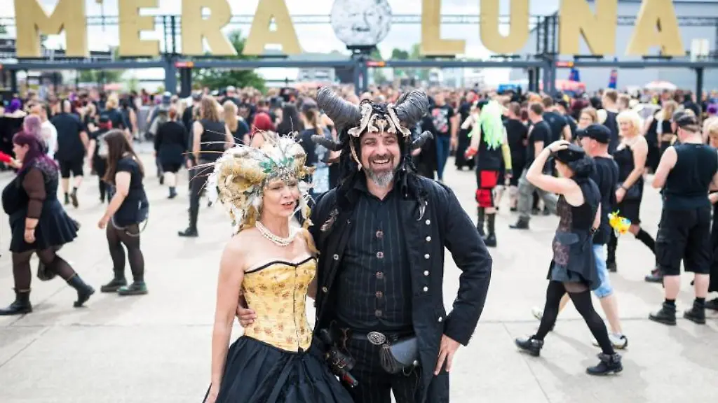 Marita-und-Jochen-aus-Mittelfranken-laufen-ueber-das-Veranstaltungsgelaende-des-M-era-Luna-Festivals