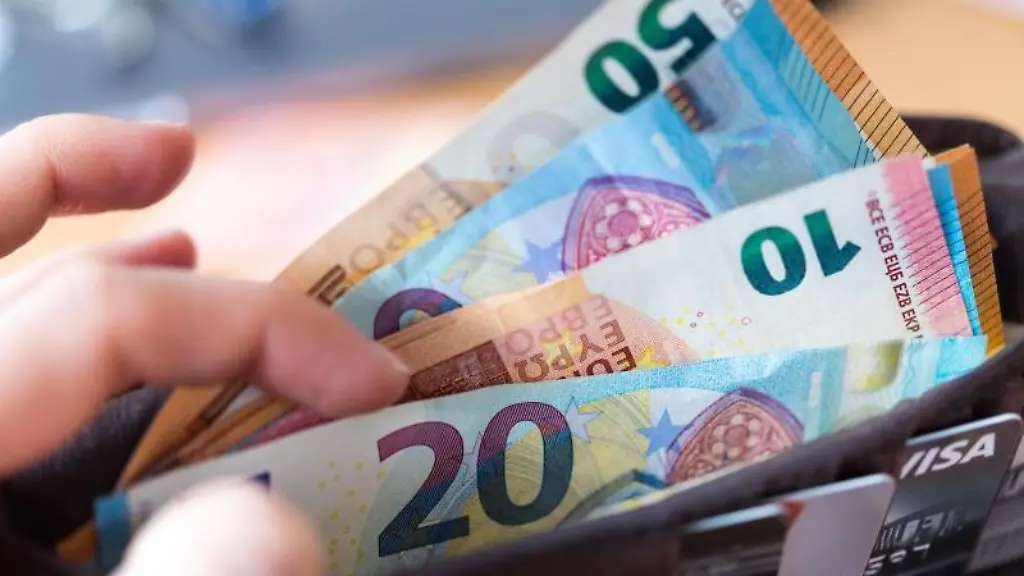Eine-Frau-haelt-eine-Geldboerse-mit-zahlreichen-Banknoten-und-Bankkarten-in-der-Hand