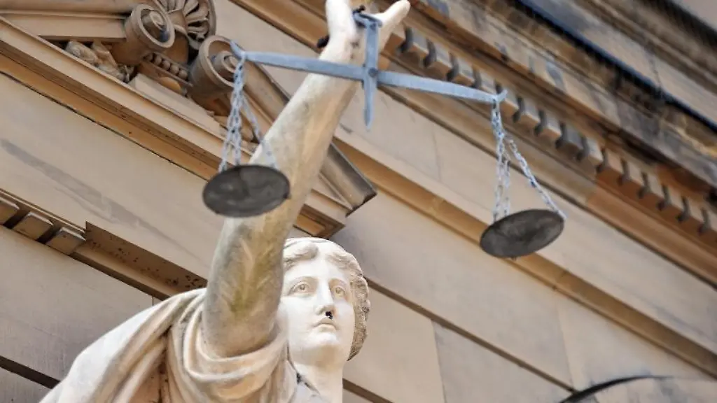 Eine-Statue-der-Goettin-Justitia-mit-einer-Waage-in-ihrer-Hand-Foto-S