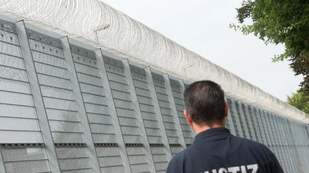 Ein-Justizbeamter-steht-vor-einer-Justizvollzugsanstalt