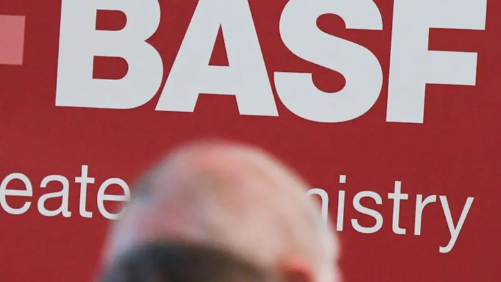 Aktionaere-stehen-bei-der-Hauptversammlung-des-Chemiekonzerns-BASF-vor-einem-Logo
