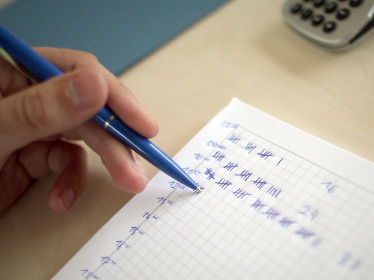 Ein Wahlhelfer notiert in einem Hamburger Wahllokal die Wahlbeteiligung.