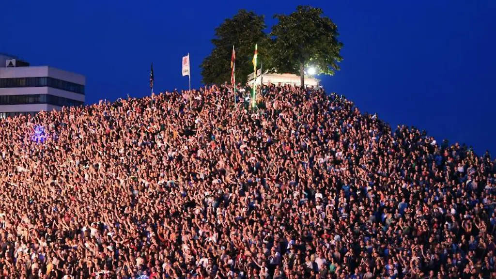 Besucher-des-Open-Air-Festival-Das-Fest-verfolgen-am-ersten-Tag-der-Veranstaltung-den-Auftritt-einer-Band