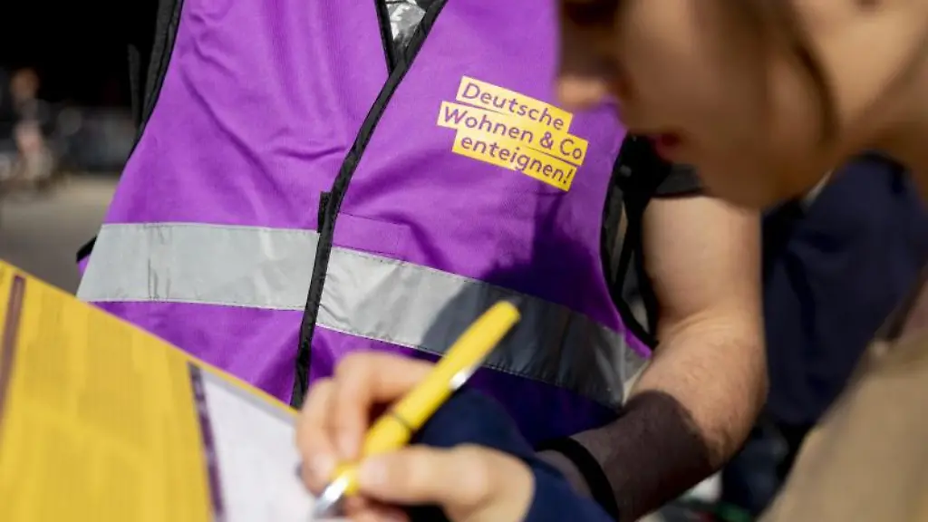 Eine-Frau-unterschreibt-bei-der-Demonstration-das-Volksbegehren-Deutsche-Wohnen-Co-enteignen