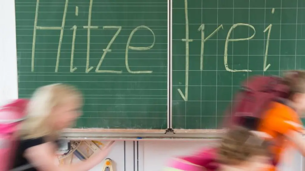 Schueler-laufen-an-einer-Tafel-Hitzefrei-vorbei