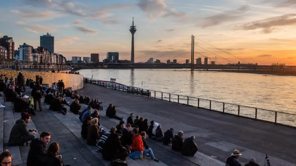 Menschen-sitzen-bei-Sonnenuntergang-am-Rhein