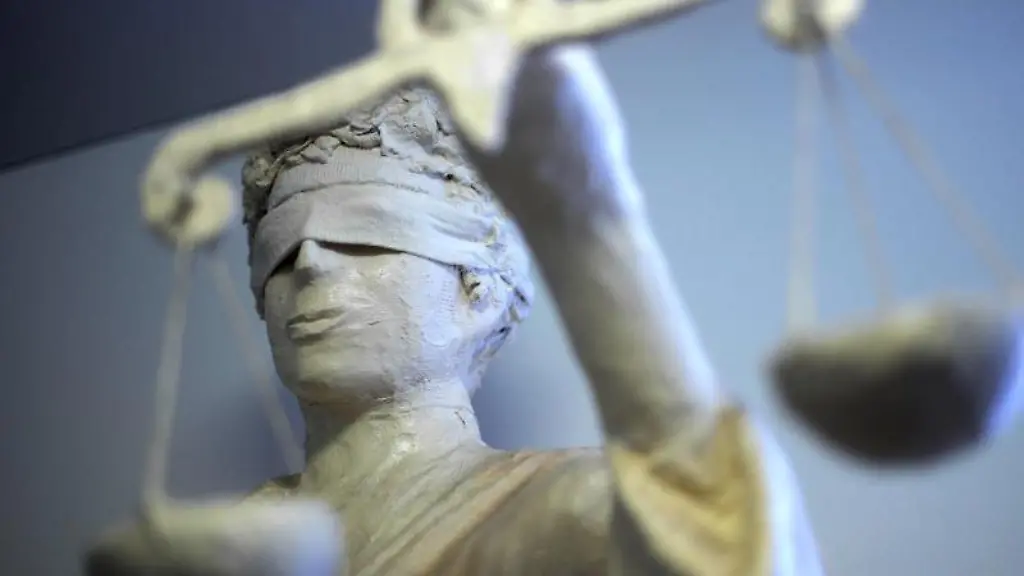 Die-Statue-Justitia-haelt-eine-Waage-in-ihrer-Hand