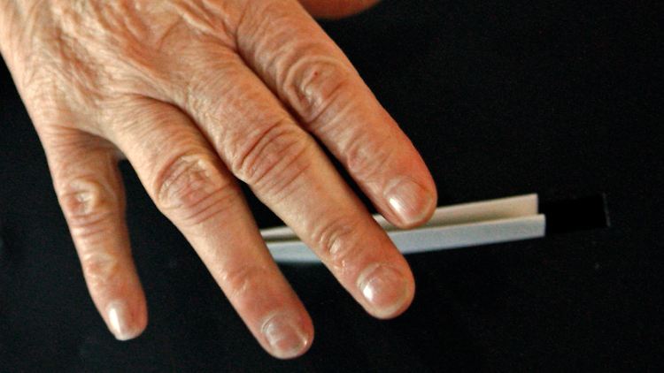 In Lissabon wirft eine Wählerin ihren Stimmzettel ein.