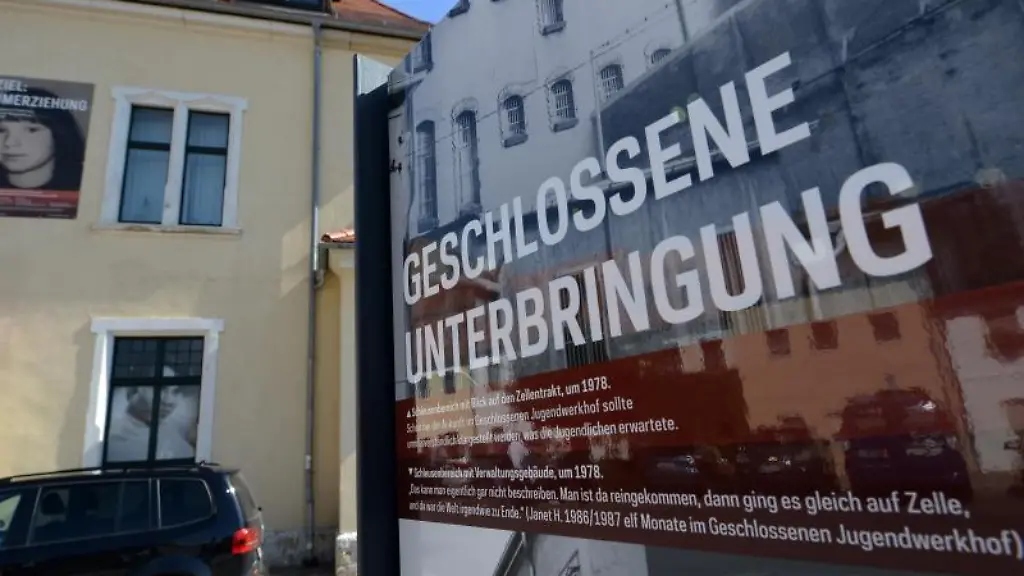 Eine-Informationstafel-steht-neben-dem-Gebaeude-des-ehemaligen-Jugendwerkhofes