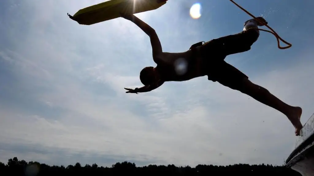 Ein-Rettungsschwimmer-springt-waehrend-einer-Rettungsuebung-der-DLRG-vom-Boot-in-einen-Badesee