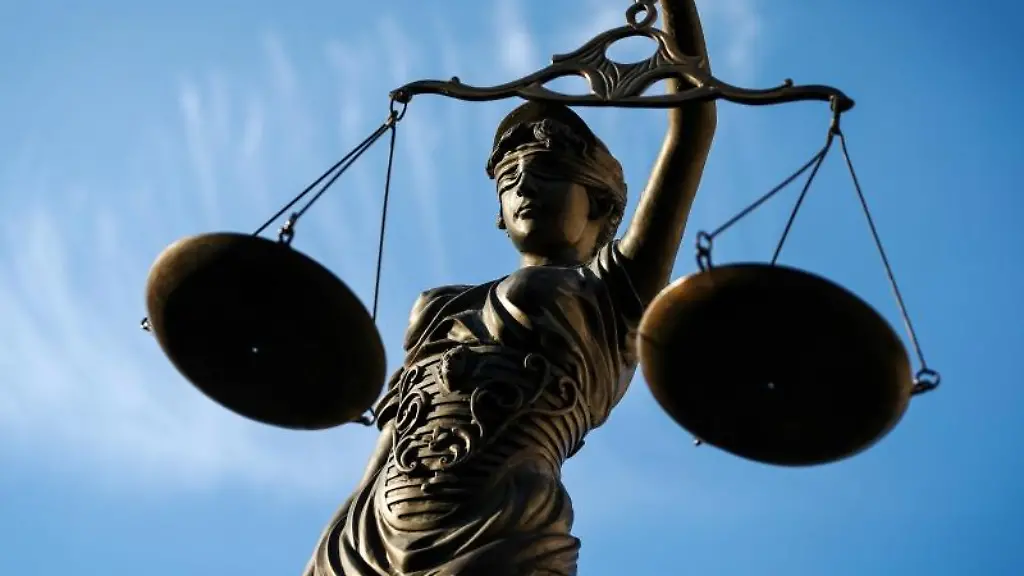 Eine-Statue-der-Justitia-haelt-eine-Waage-in-ihrer-Hand