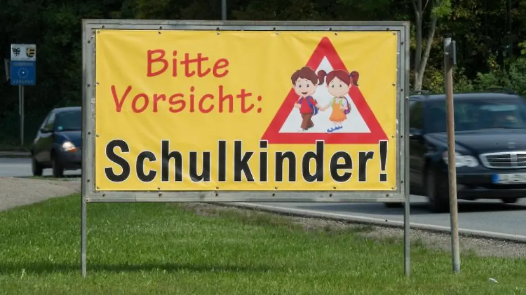 Ein-Transparent-mit-der-Aufschrift-Bitte-Vorsicht-Schulkinder-am-Ortsrand-von-Neufahrn