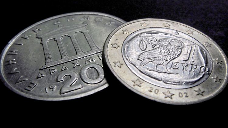 Eine griechische Euromünze (r.) und eine 20-Drachmen-Münze, die ehemalige griechische Währung.