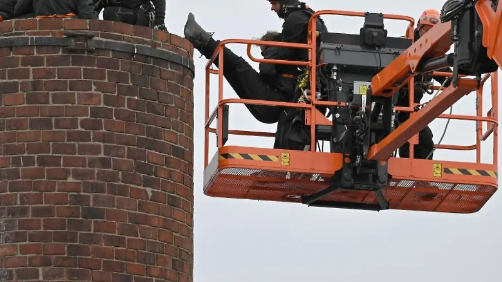 Polizisten-bergen-einen-Tierschuetzer-von-einem-Schornstein-auf-dem-Gelaende-des-Schlachthofes