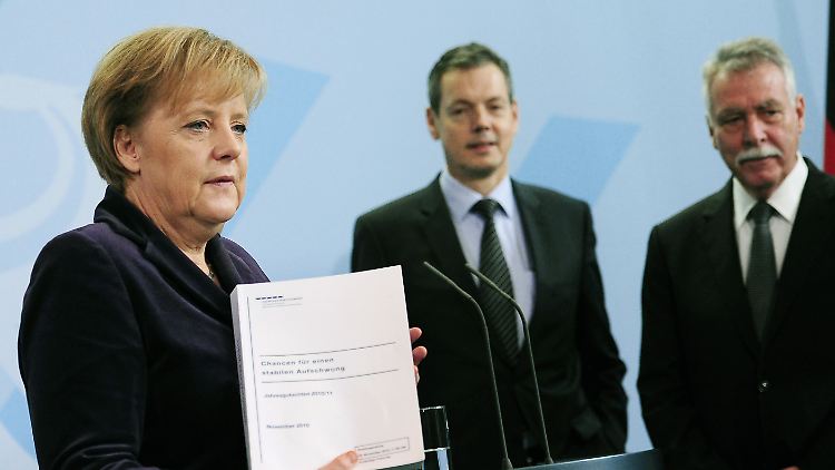 November 2010: Peter Bofinger (Mitte) überreicht der Bundeskanzlerin zusammen mit seinen Kollegen das Jahresgutachten der "Wirtschaftsweisen".