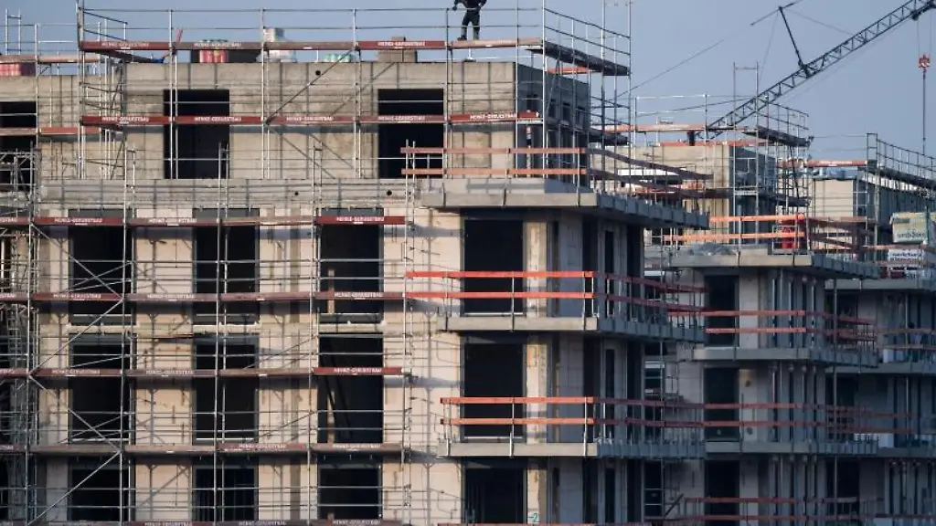 Ein-Baugeruest-steht-an-einem-Rohbau-fuer-Neubau-Wohnungen