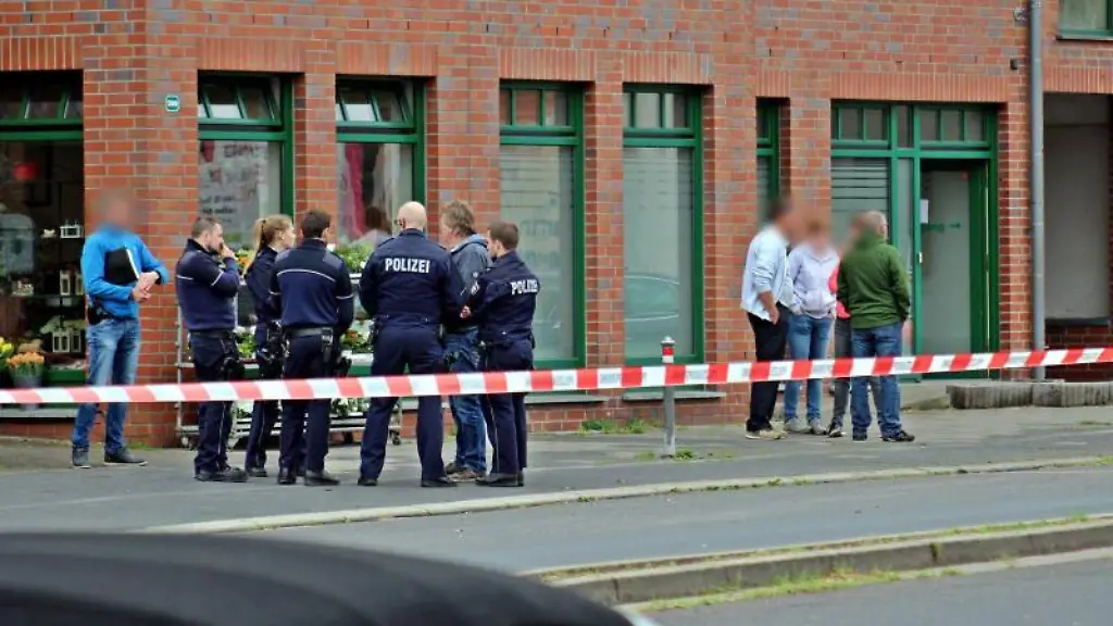 Polizisten-und-Passanten-stehen-vor-einem-Haus-in-der-Innenstadt-von-Neuss