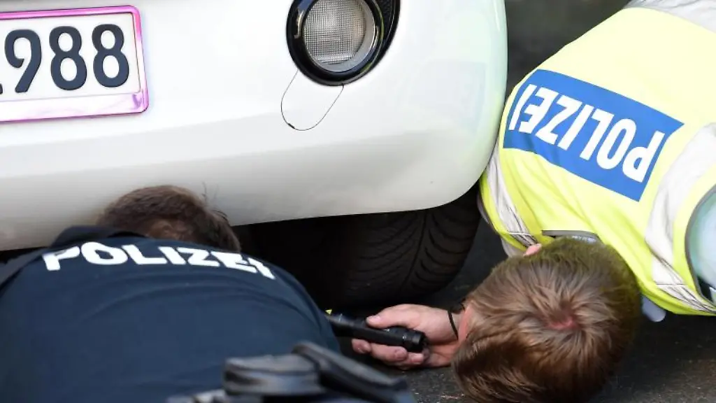 Polizisten-kontrollieren-den-Auspuff-bei-einem-getunten-Auto