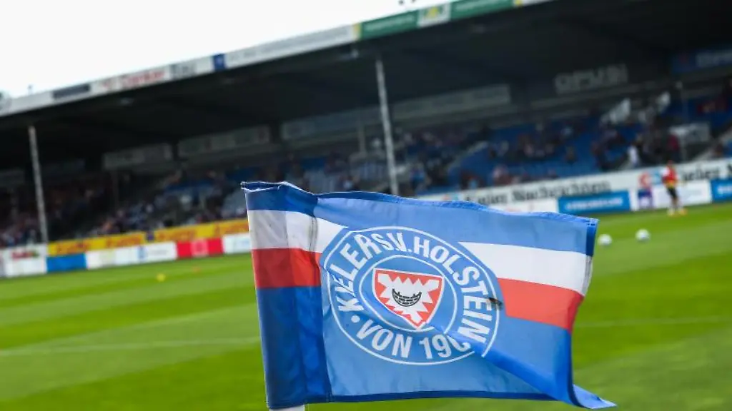 Eine-Flagge-mit-dem-Logo-der-Mannschaft-von-Holstein-Kiel-steckt-auf-der-Eckfahne-im-Stadion