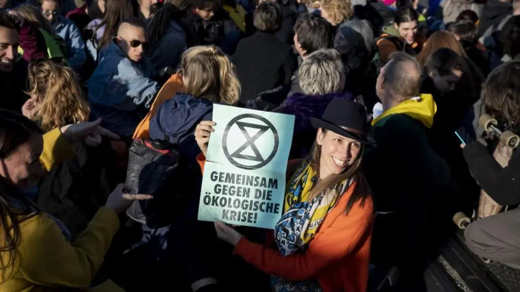 Gemeinsam-gegen-die-oekologische-Krise-steht-bei-einer-Sitz-Blockade-auf-der-Oberbaumbruecke-auf-dem-Plakat-einer-Teilnehmerin