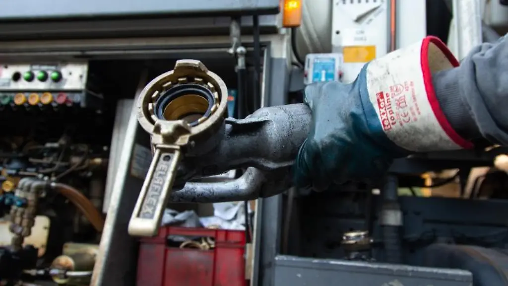 Der-Fahrer-eines-Tanklasters-haelt-die-Zapfpistole-fuer-die-Auslieferung-von-Heizoel-in-den-Haenden