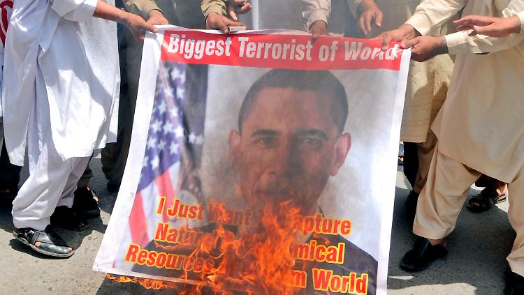 Muslime verbrennen in Pakistan ein Banner mit dem US-Präsidenten.