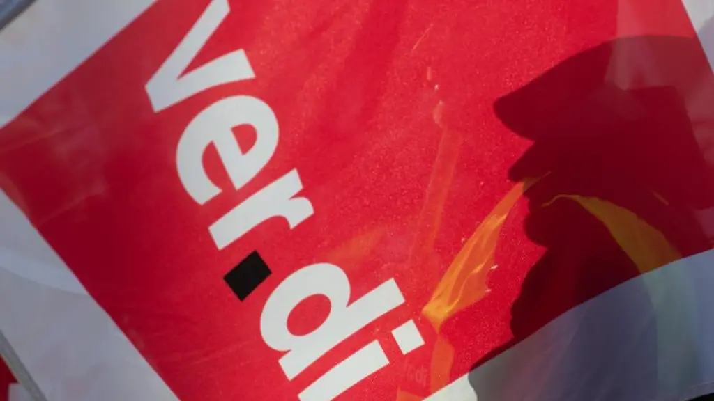 Der-Schatten-eines-Teilnehmers-am-Warnstreik-faellt-auf-eine-Fahne-der-Gewerkschaft-Verdi