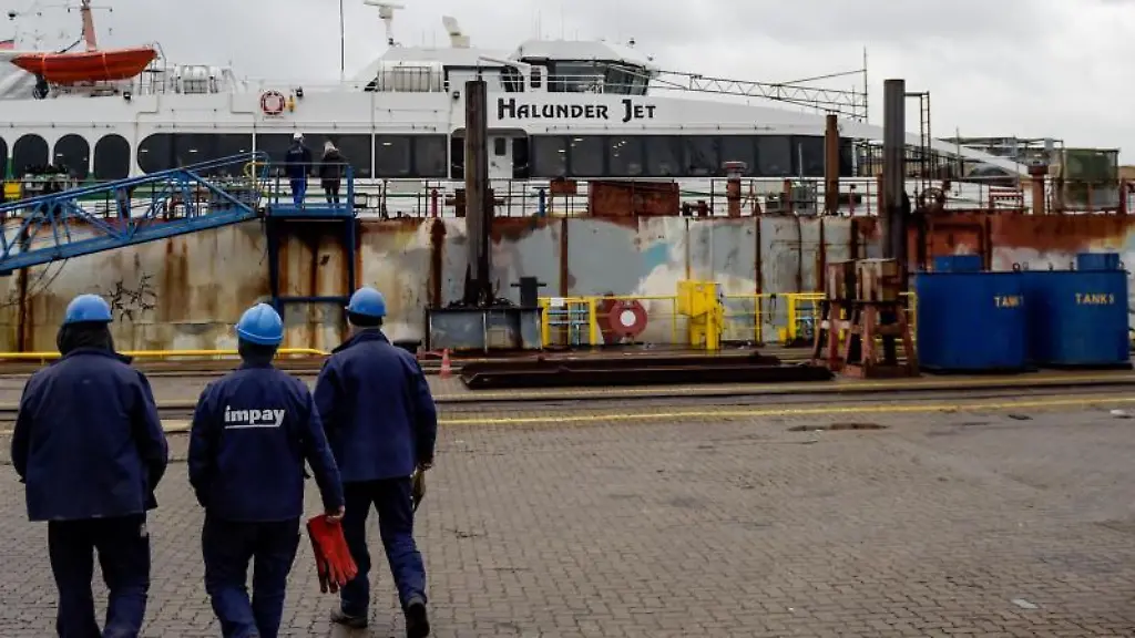 Arbeiter-gehen-in-der-Hamburger-Norderwerft-auf-den-im-Dock-liegenden-Halunder-Jet-zu