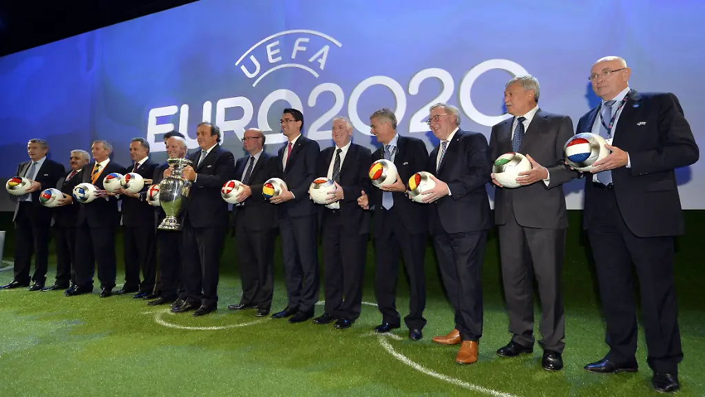 Michel-Platini-mit-Pokal-inmitten-von-Vertretern-der-Gastgebernationen